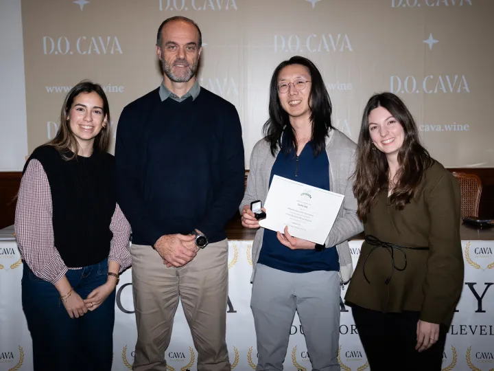 Leon holding a certificate alongside three other people.
